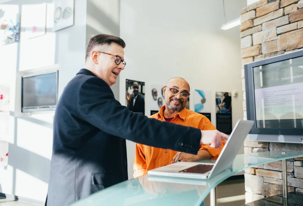a person pointing at a laptop